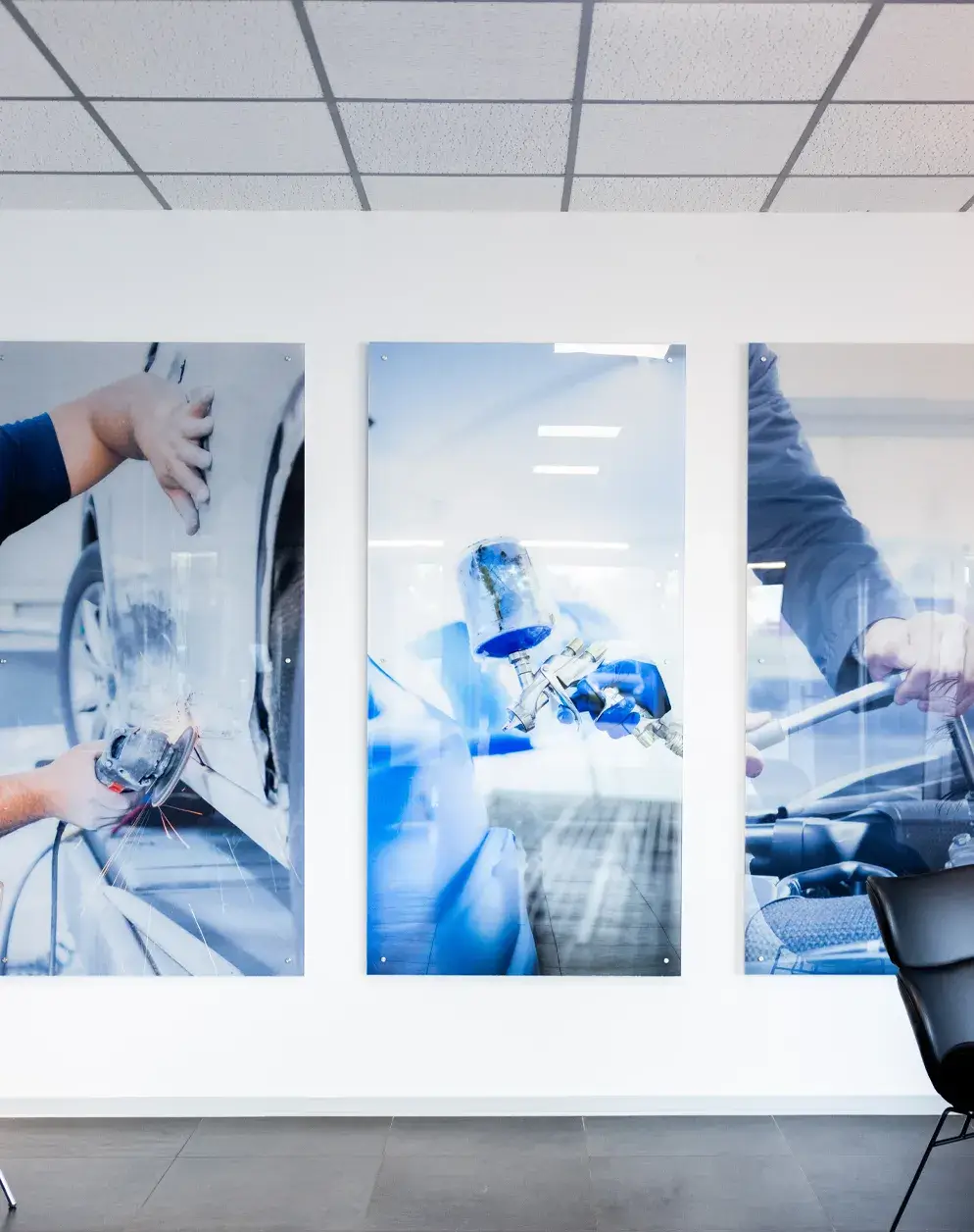 Wandbilder mit Motiven aus der Karosserie- und Lackierarbeit im Empfangsbereich von Karosserie Blanke